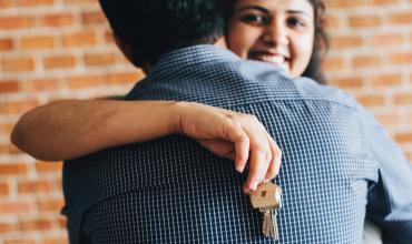 3 Resolutions to Help You Buy a Home in 2019 a woman holding a house key hugging a man