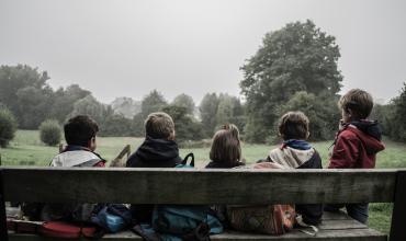 Nationwide Data Maps Out Where Poor Children Have the Best Chance to Get Ahead Four children sitting on a bench with their backs to the photographer