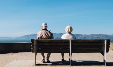 New Report Highlights Boomers’ Housing Affordability Struggle Older couple sitting on a bench facing mountains