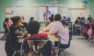 Perception = Reality for Housing-Education Connection Kids in a classroom with a teacher in front of the dry erase board
