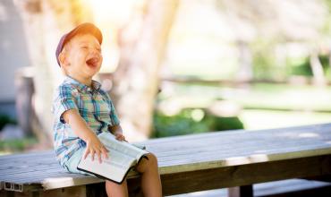 NOFA a boy laughing on a bench
