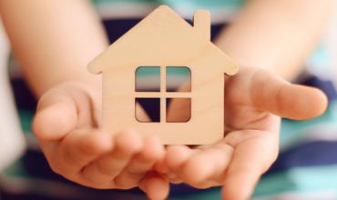 Children in Housing hand holding a house