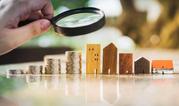 North Carolina to Gain More Than $973 Million in Affordable Housing Development Money and apartments underneath a magnifying glass