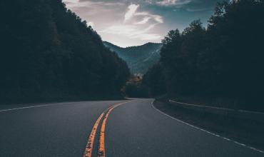 Buying a Home from Across the State? a closeup photo of a road with mountains on either side