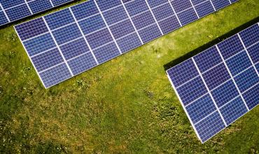 Energy Efficiency Linked to Lower Commercial Mortgage Default Rates Energy panels against grass background