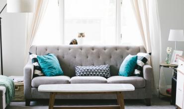 How to Deep Clean Before You Move a gray couch with turquoise pillows