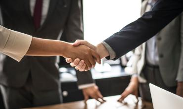 3 Myths About Hiring a Real Estate Agent—Busted! two real estate agents and their clients shaking hands
