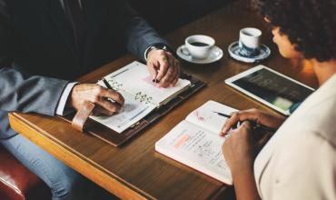 Understanding the Four Parts of a Mortgage Payment two people sitting at a table with notebooks