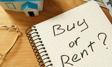 Renting v. Buying: Which is Right for You? a notebook with buying vs. renting written on it