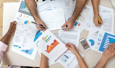 Millennials and Baby Boomers Increasingly Shape Housing Demand a group of individuals at a desk working over some documents