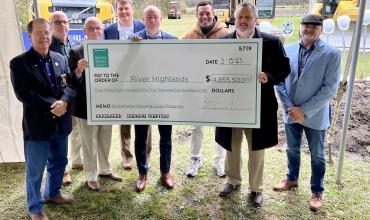 People holding up a giant check