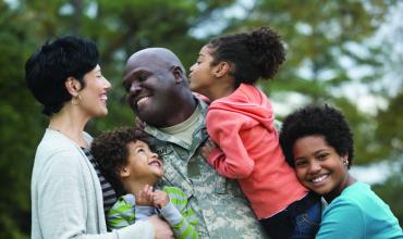 VA Home Loan FAQ a veteran in uniform hugging his family