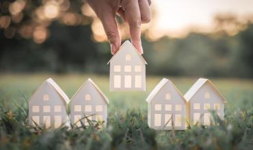 This June, Make Home Happen Three little lantern houses sitting on the lawn of a home