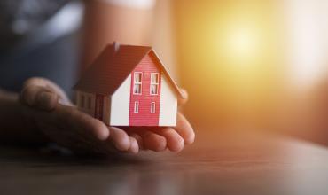 NC Housing Finance Agency Increases Housing Opportunities for At-Risk North Carolinians A little model house sitting in someone's hands