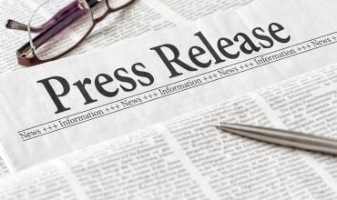 NC Housing Finance Agency Executive Director Reelected to National Council of State Housing Agencies’ 2023 Board of Directors A newspaper that says Press Release on it with glasses and a pen laying on top