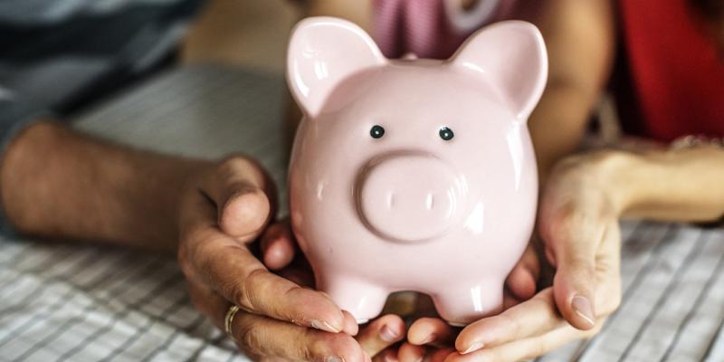 Debt-to-Income Ratio Explained hands holding a pink piggy bank