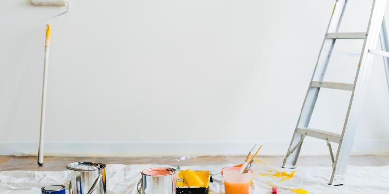 Moving Up? Easy Updates to Sell Your Home Quickly Blank wall with paint supplies on the ground and a ladder