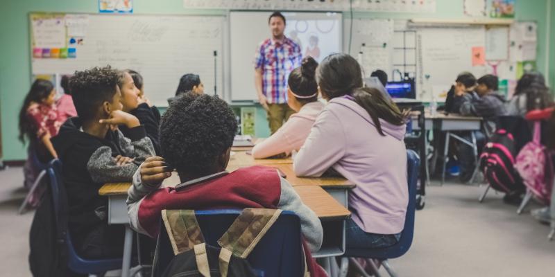 Perception = Reality for Housing-Education Connection Kids in a classroom with a teacher in front of the dry erase board