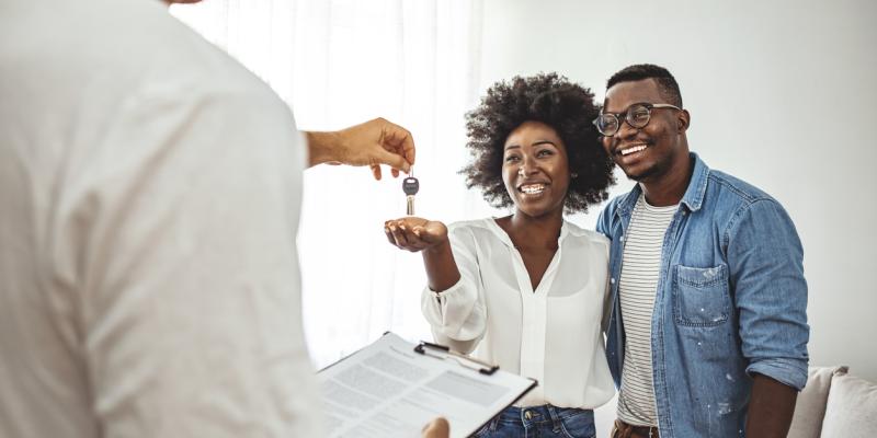 Future of Home Ownership Couple accepting keys from a real estate agent