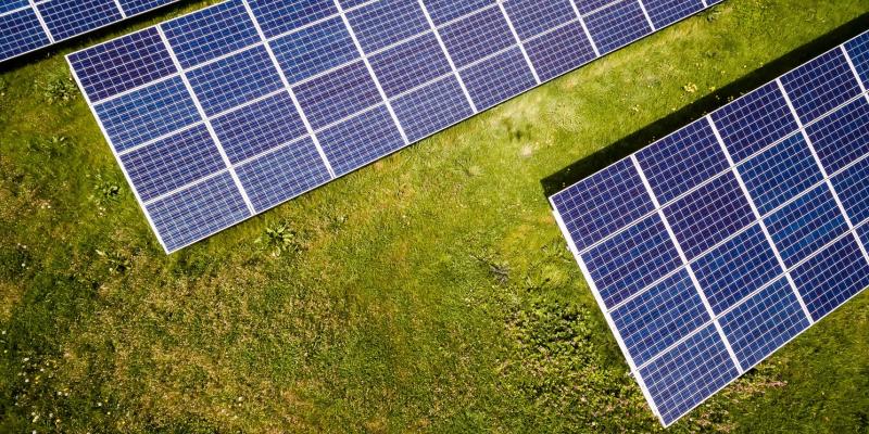 Energy Efficiency Linked to Lower Commercial Mortgage Default Rates Energy panels against grass background