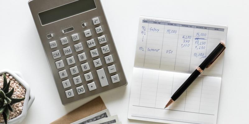 Money Tips for Home Buyers a table with a calculator, checkbook and pen