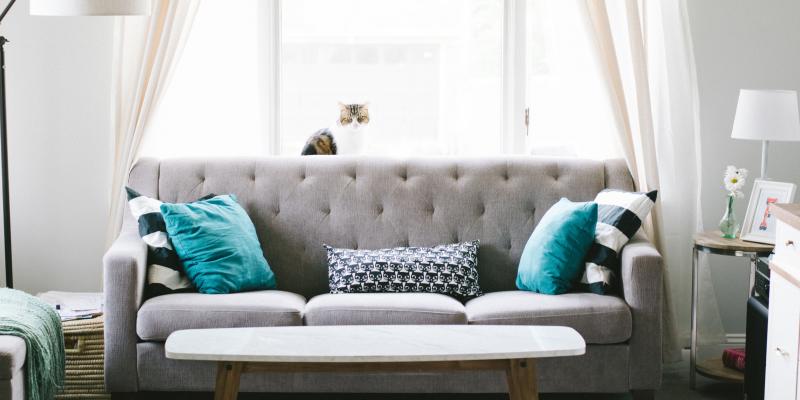 How to Deep Clean Before You Move a gray couch with turquoise pillows