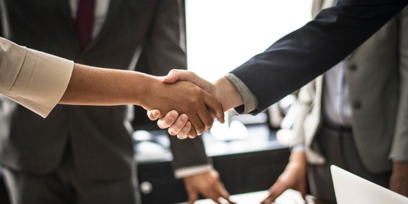 3 Myths About Hiring a Real Estate Agent—Busted! two real estate agents and their clients shaking hands