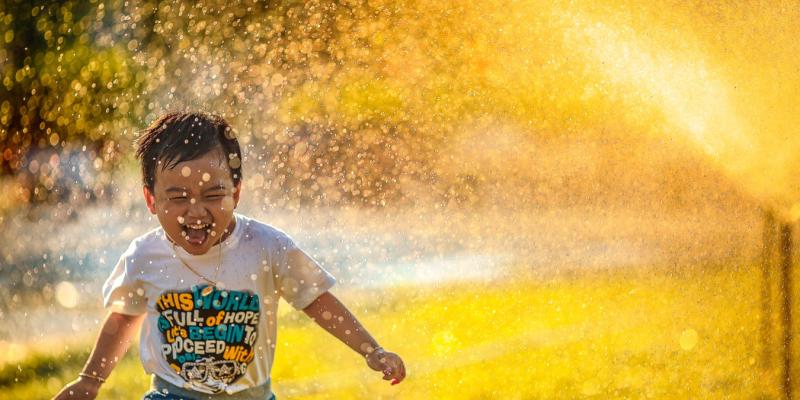 Don’t Let These Home Buying Myths Fool You! a kid running through a sprinkler