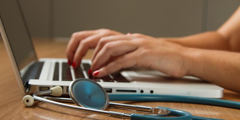 National Initiative Links Affordable Housing with Health Outcomes A stethoscope laying next to a person typing on a computer